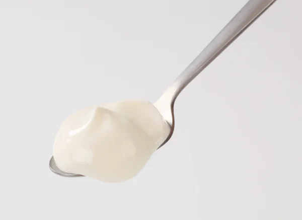Белый йогурт на ложке — стоковое фото