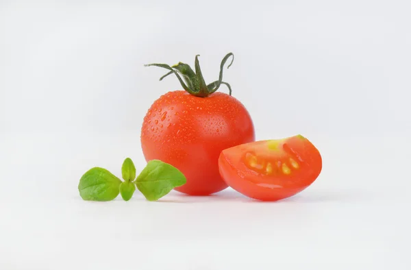 Весь красный помидор и четверть — стоковое фото