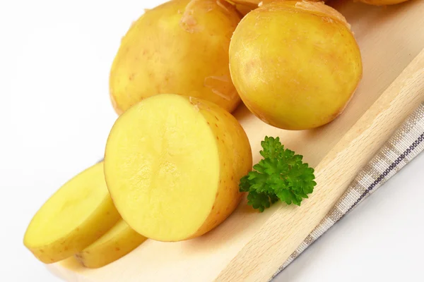 Batatas cruas na tábua de corte — Fotografia de Stock