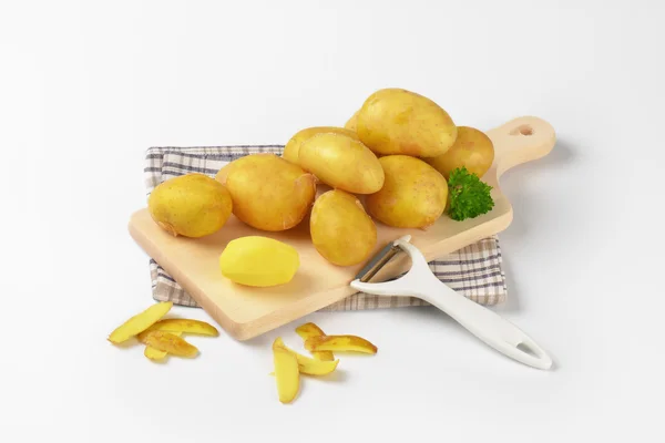 Batatas frescas na tábua de corte — Fotografia de Stock