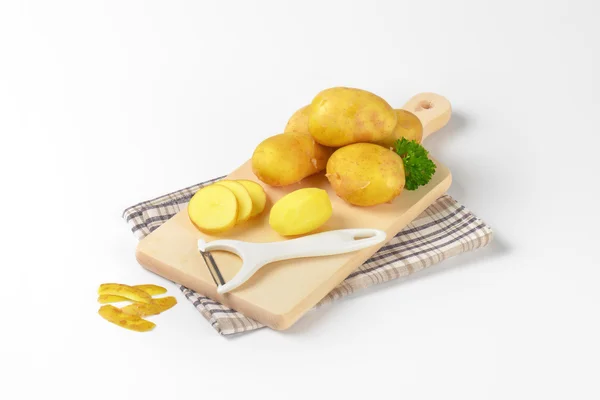 Fresh potatoes on cutting board — Stock Photo, Image