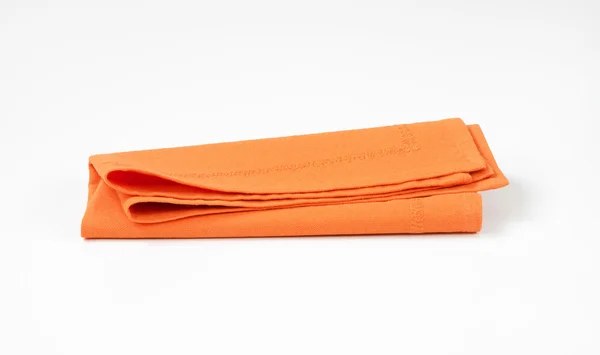 Guardanapo laranja dobrado — Fotografia de Stock