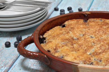 Blueberry cobbler in a pottery casserole dish. Macro close up with selective focus.