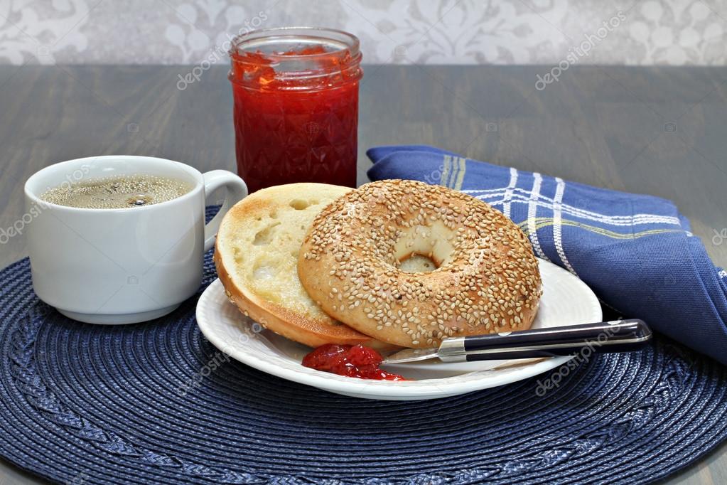 Sesame bagel, toasted and buttered with homemade strawberry jam — Stock