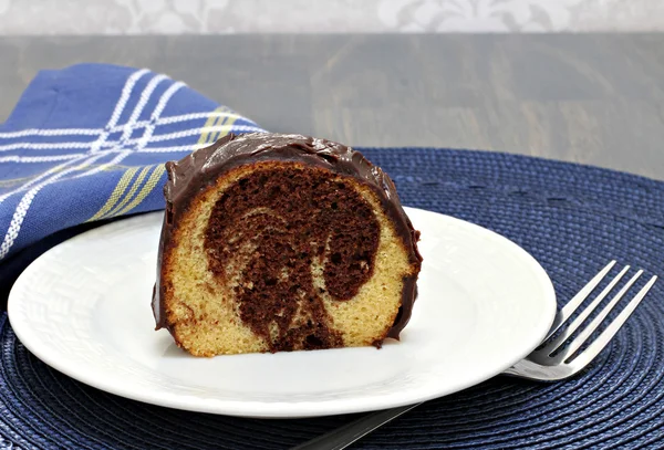 Uma fatia de chocolate e baunilha torcido bolo com chocolate i — Fotografia de Stock