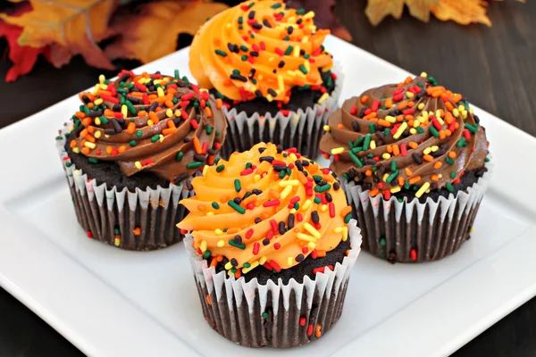 Pasteles de chocolate de otoño con glaseado de naranja y chocolate y —  Fotos de Stock