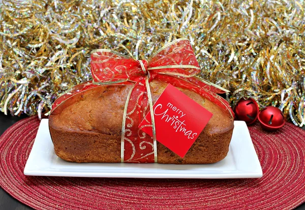 Bolo de libra com uma fita de Natal e cartão de Natal feliz . — Fotografia de Stock