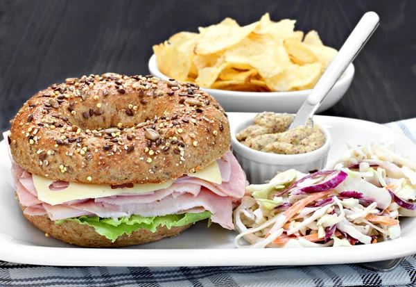 Bagel-Schinken, Käse-Salat-Sandwich mit einer Seite würzigem Senf — Stockfoto