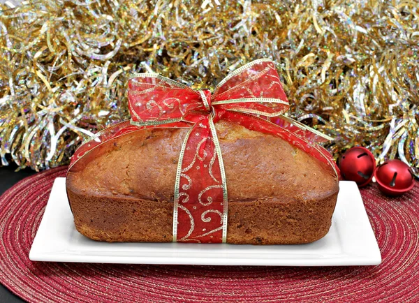 Whole loaf cake wrapped in a red and gold ribbon. — Stock Photo, Image