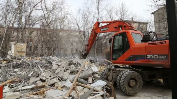 Grävmaskin maskiner som arbetar med rivning gamla hus. Moscow, Ryssland — Stockvideo