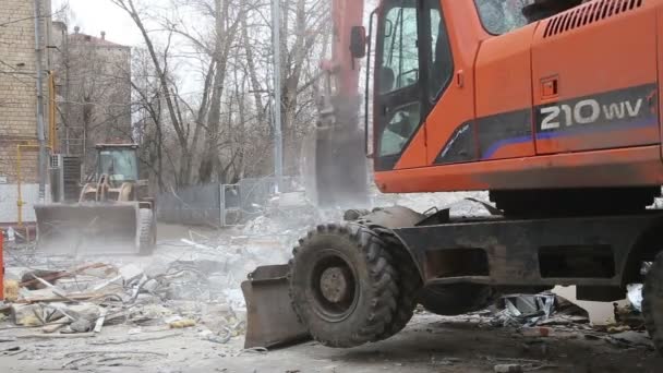 Grävmaskin maskiner som arbetar med rivning gamla hus. Moscow, Ryssland — Stockvideo