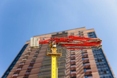 Arka planda çok katlı bina (yeni konut kompleksi) inşa edilmiş beton pompa (pompa kamyonu), Moskova, Rusya  