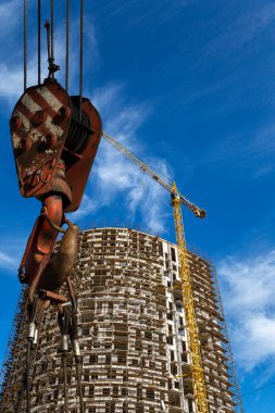 İnşaat vinci kancası ile inşa halindeki çok katlı bina arka planda (yeni iskan kompleksi), Moskova, Rusya