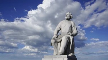 Uzay Anıtı Fatihleri (hareket halindeki bulutlara karşı) yakınlarındaki VDNK sergi merkezi yakınlarındaki Kozmonotlar Müzesi 'nin parkında bulunan Tsiolkovsky anıtı, Moskova, Rusya 