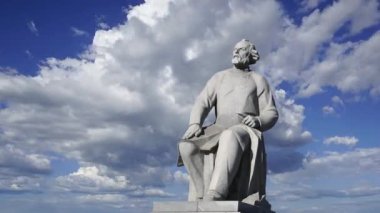 Uzay Anıtı Fatihleri (hareket halindeki bulutlara karşı) yakınlarındaki VDNK sergi merkezi yakınlarındaki Kozmonotlar Müzesi 'nin parkında bulunan Tsiolkovsky anıtı, Moskova, Rusya 