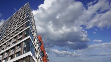 Hareket halindeki bulutlara karşı çok katlı bina (yeni yerleşim kompleksi) inşa ediliyor, Moskova, Rusya 
