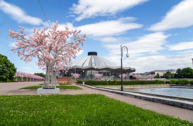 MOSCOW, Rusya- HAZİRAN 05, 2021: Vernadskogo Prospekt Moskova Devlet Sirki 'ne güneşli bir günde çiçek açan bahar ağaçları ile bakın