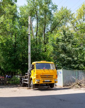 MOSCOW, RUSSIA - 23 Haziran 2021: bir yerleşim yerinin avlusunda hidrolik kaldırma tesisi olan bir araba. Kuru dallar budamak, hasarlı ağaçları kesmek, kronlama. Şehir hizmetlerinin çalışması.