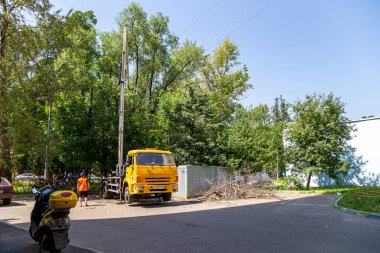 MOSCOW, RUSSIA - 23 Haziran 2021: bir yerleşim yerinin avlusunda hidrolik kaldırma tesisi olan bir araba. Kuru dallar budamak, hasarlı ağaçları kesmek, kronlama. Şehir hizmetlerinin çalışması.