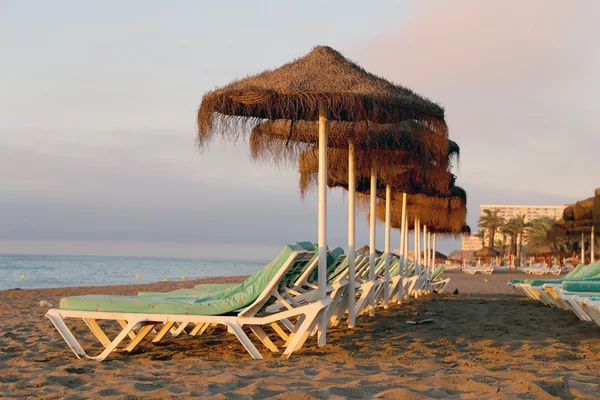 Stranden solstol och parasoll på lonely sandstrand. Costa del sol (kusten av solen), malaga i Andalusien, Spanien — Stockfoto