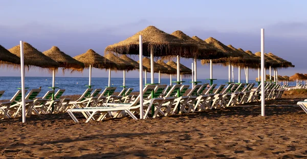 Cadeira lounge de praia e guarda-chuva na praia solitária. Costa del Sol, Málaga na Andaluzia, Espanha — Fotografia de Stock