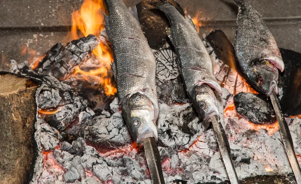 Cooking fish grilled over hot coals bonfire — Stock Photo, Image