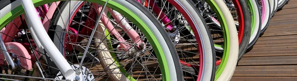 Row multicolored bicycle wheels closeup — Stock Photo, Image