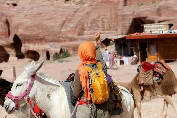 Turystycznych i osły wśród krajobrazu pustyni piaskowiec w Petra, Jordan — Zdjęcie stockowe