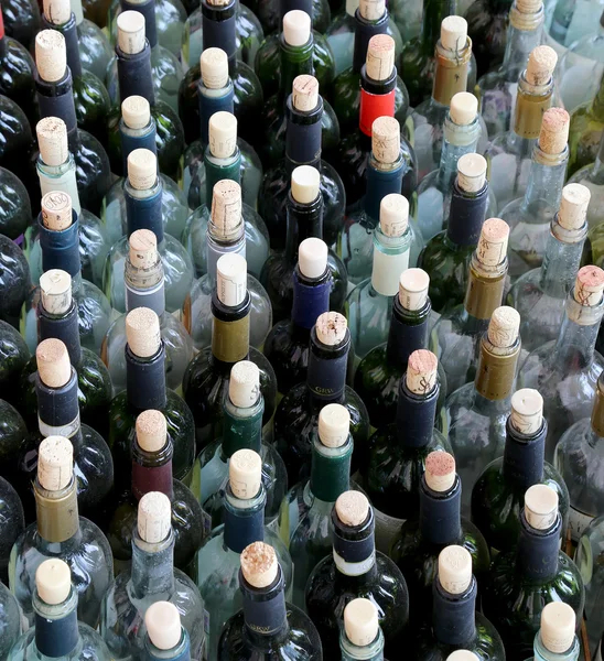 Mucho apiladas botellas de vino con corchos — Foto de Stock