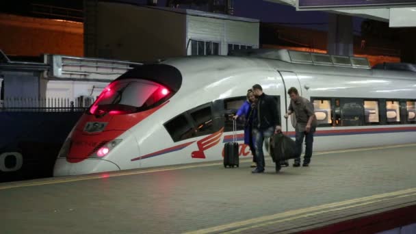 Aeroexpress Train Sapsan y los pasajeros en la estación de tren Leningradsky (noche). Moscú, Rusia — Vídeos de Stock