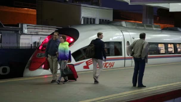 Aeroexpress Train Sapsan e passageiros na estação ferroviária de Leningradsky (noite). Moscou, Rússia — Vídeo de Stock