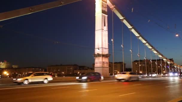 El puente Krymsky o el puente De Crimea y el tráfico de los coches (de noche) es un puente colgante de acero en Moscú, Rusia. El puente atraviesa el río Moskva a 1.800 metros al suroeste del Kremlin — Vídeo de stock