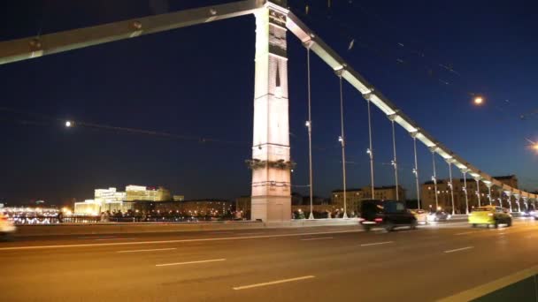 Krymsky Bridge of Krim Bridge en het verkeer van auto's (nacht)--is een stalen hangbrug in Moskou, Rusland. De brug overspant de Moskva rivier 1.800 meter ten zuidwesten van het Kremlin — Stockvideo