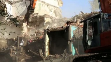 Hidrolik kırıcı ekskavatör makine yıkım eski ev üzerinde çalışıyor. Moskova, Rusya