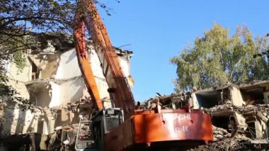 Hidrolik kırıcı ekskavatör makine yıkım eski ev üzerinde çalışıyor. Moskova, Rusya