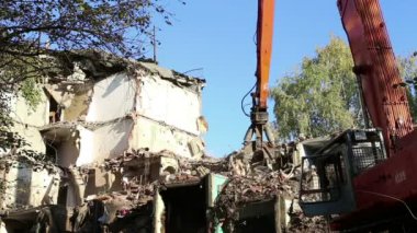 Hidrolik kırıcı ekskavatör makine yıkım eski ev üzerinde çalışıyor. Moskova, Rusya