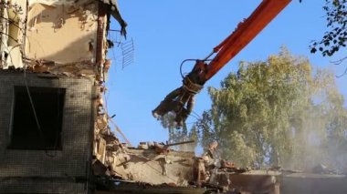Hidrolik ezici kazıcı makineleri eski evi yıkmaya çalışıyor.