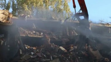 Hidrolik ezici kazıcı makineleri eski evi yıkmaya çalışıyor.