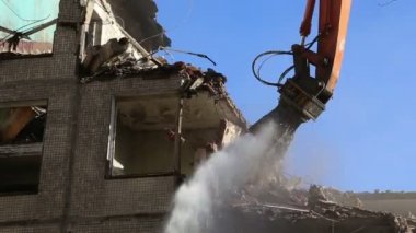 Hidrolik ezici kazıcı makineleri eski evi yıkmaya çalışıyor.