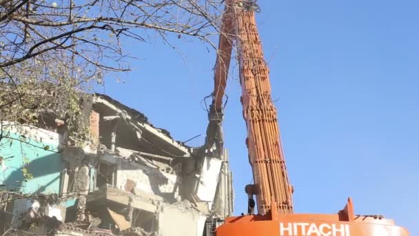 Frantoio idraulico escavatore macchinari che lavorano sulla demolizione vecchia casa.Mosca, Russia — Video Stock