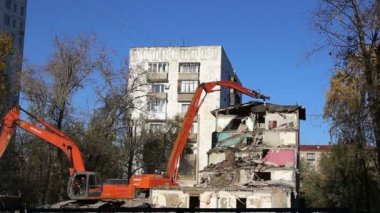 Hidrolik kırıcı ekskavatör makine yıkım eski ev üzerinde çalışıyor. Moskova, Rusya