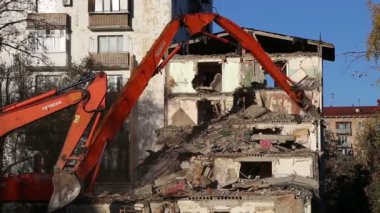 Hidrolik kırıcı ekskavatör makine yıkım eski ev üzerinde çalışıyor. Moskova, Rusya