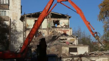 Hidrolik kırıcı ekskavatör makine yıkım eski ev üzerinde çalışıyor. Moskova, Rusya