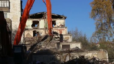Hidrolik kırıcı ekskavatör makine yıkım eski ev üzerinde çalışıyor. Moskova, Rusya