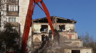 Hidrolik kırıcı ekskavatör makine yıkım eski ev üzerinde çalışıyor. Moskova, Rusya