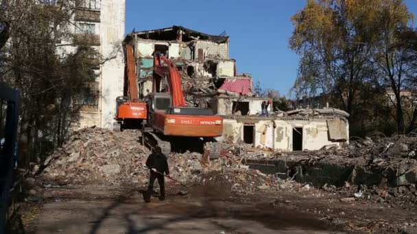 Hydraulisk kross grävmaskin maskiner arbetar på rivning gammalt hus. Moscow, Ryssland — Stockvideo