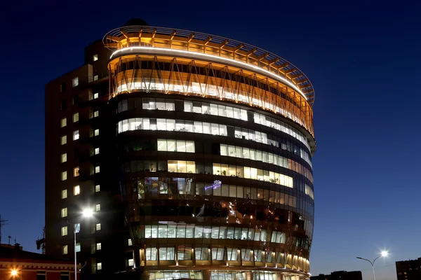 modern office building with big windows at night, in windows light shines.Moscow, Russia