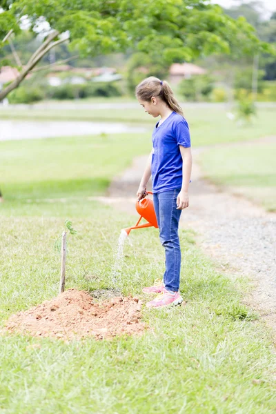 Glückliches Mädchen, das Pflanzen im Freien gießt — Stockfoto