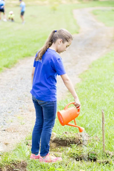 Happy Girl watering plants Outdoors — Stock Photo, Image