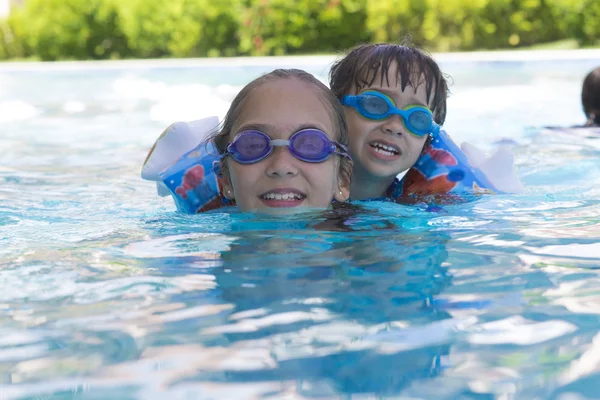 Chica feliz y niño disfrutando en la piscina —  Fotos de Stock